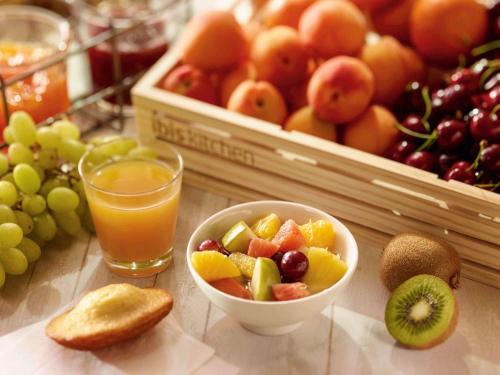 a table with a bowl of fruit and a glass of orange juice at Ibis Madrid Getafe in Getafe