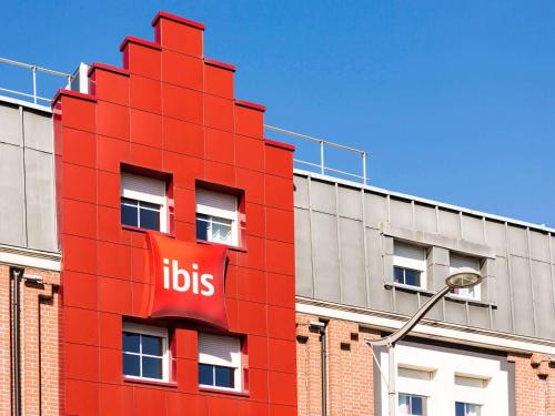 a red building with aubs sign on the side of it at ibis Lille Lomme Centre in Lomme