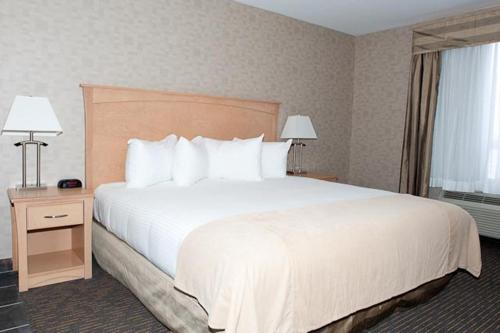 a hotel room with a large bed with white pillows at Paradise Inn and Suites in Valleyview