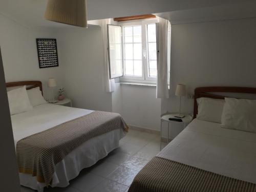 a bedroom with two beds and a window at Pension Rosalia de Castro in Foz