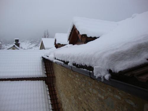 a roof covered in snow on top of a house at O´Porron in Sabiñánigo