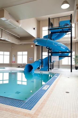 a swimming pool with a slide in a building at Paradise Inn and Suites in Valleyview