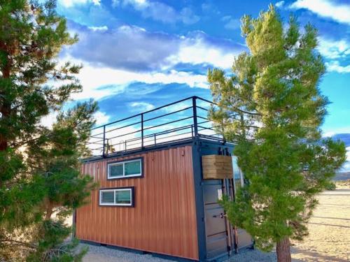 a small cabin with a tree in front of it at The Castle House Estate in Joshua Tree