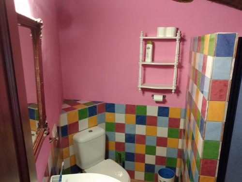 a bathroom with a toilet and a colorful wall at Casablanca in Yunquera