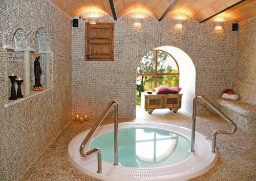 - une salle de bains avec baignoire dans une chambre avec fenêtre dans l'établissement Hotel Golf Can Rafel, à Corbera de Llobregat