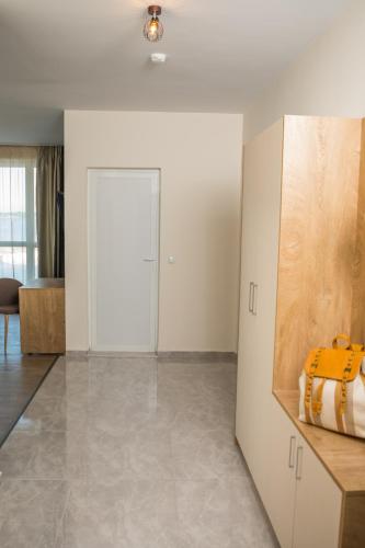 a living room with white walls and tile floors at Allure Beach Resort Aparthotel in Primorsko