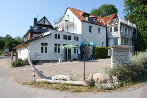 a large white house with a boat in front of it at Schlafstrandkorb Nr.2 in Sierksdorf
