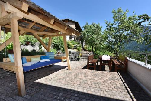 a wooden gazebo with a table and benches on a patio at Mottnerhof in Braz