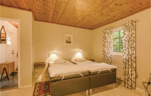 a bedroom with a bed with a wooden ceiling at Stunning Home In Fristad With Wifi in Tämta