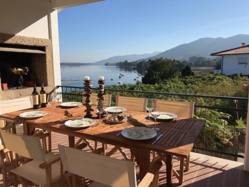a wooden table on a balcony with a view of the water at Swedish House in Caminha