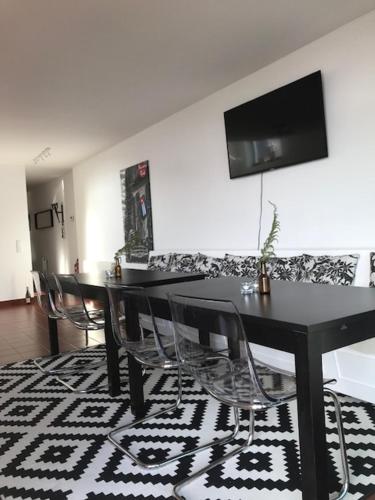 a dining room with a black table and chairs at Swedish House in Caminha