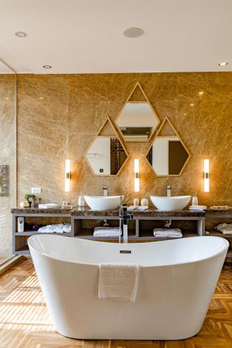 a bathroom with two sinks and a bath tub at Lighthouse Golf & Spa Hotel - Mineral Pools, Premium All Inclusive, SPA & Beach Access, Free Parking in Balchik