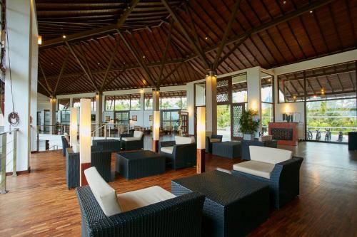 eine Lobby mit Sofas, Tischen und Fenstern in der Unterkunft The Calm Resort & Spa in Pasikuda