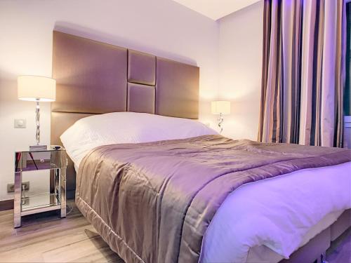 - une chambre avec un grand lit et une table de chevet dans l'établissement 16 Quai Saint-Pierre, à Cannes