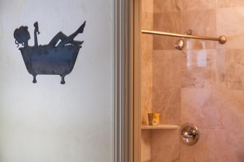 a bathroom with a shower with a bird bath on the wall at The Vendange Carmel Inn & Suites in Carmel