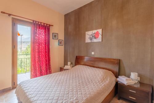 a bedroom with a bed with a red curtain and a window at Cosy apartment in Stoupa in Stoupa