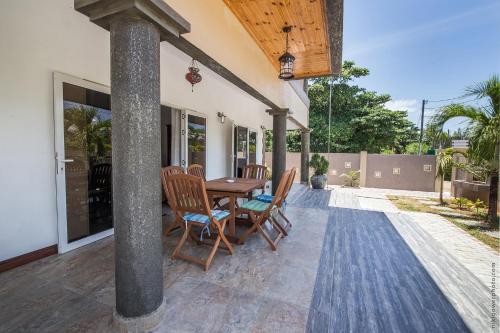 a patio with a wooden table and chairs at Flora's Self Catering Apartments in Victoria