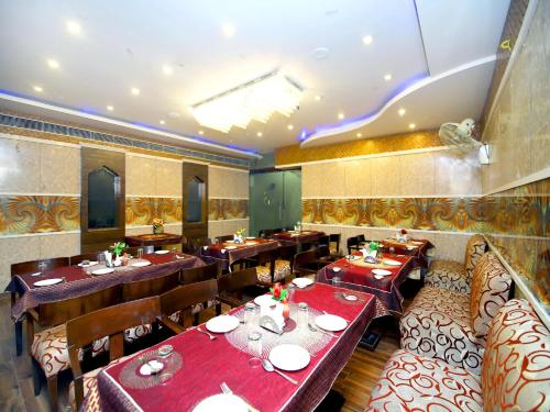 a restaurant with tables and chairs with red table cloth at Hotel Sanjog International in Amritsar
