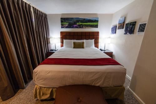 a bedroom with a large bed in a hotel room at The Vendange Carmel Inn & Suites in Carmel