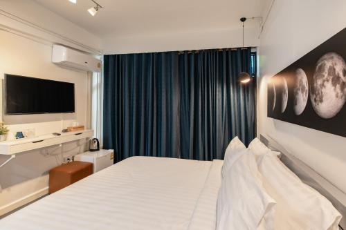 a hotel room with a bed and a television at Every Surawong in Bangkok