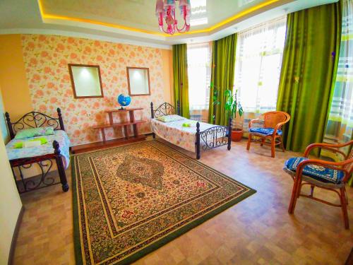 a bedroom with a bed and two chairs and a rug at Kurak Homestay in Bishkek