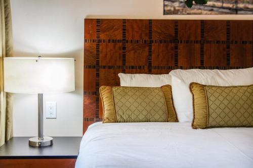 a bedroom with a bed with a lamp and pillows at The Vendange Carmel Inn & Suites in Carmel