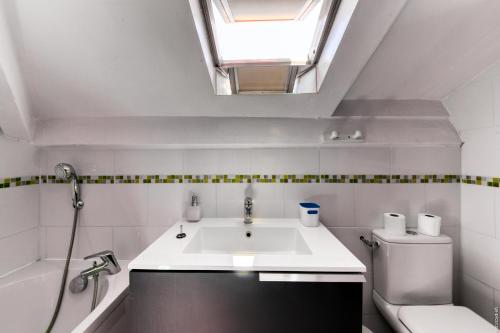 a bathroom with a sink and a toilet and a skylight at Glamorgan in Antibes