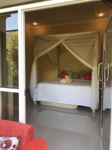 a bedroom with a bed with a teddy bear on it at Sekumpul BnB in Singaraja