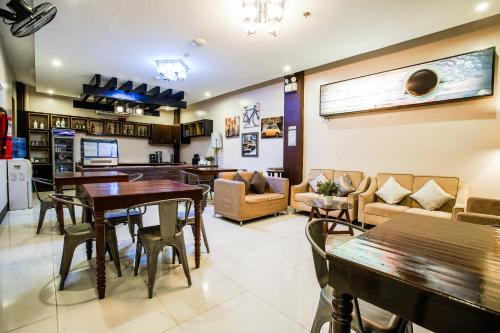eine Küche und ein Wohnzimmer mit Tischen und Stühlen in der Unterkunft OYO 236 Hotel Edmundo in Pototan