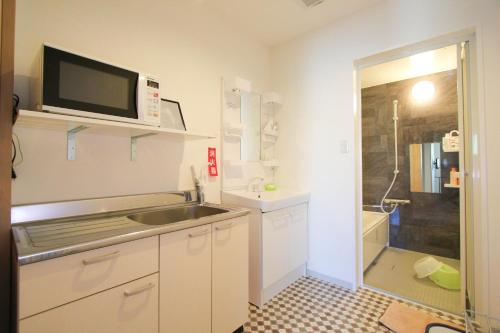 a small kitchen with a sink and a microwave at kyowara Tenjin / Vacation STAY 6821 in Kyoto