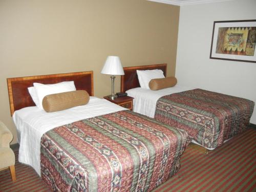 um quarto de hotel com duas camas e um candeeiro em The Surrey Inn em Caldwell