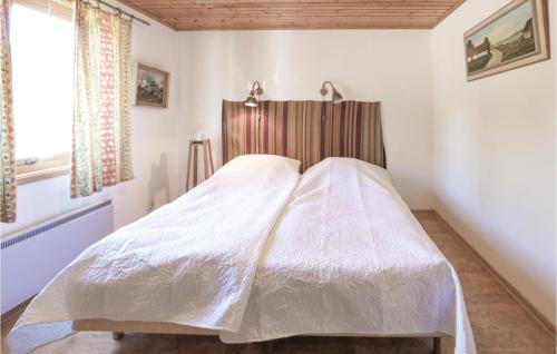 Schlafzimmer mit einem weißen Bett mit einem Kopfteil aus Holz in der Unterkunft Awesome Home In Nybrostrand With Wifi in Kabusa