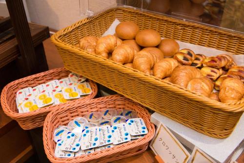three baskets filled with bread and eggs on a table at Hotel Kuretakeso Takayama Ekimae in Takayama