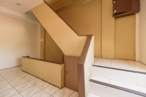 an empty room with stairs in a house at RedDoorz Syariah near Simpang Surabaya Aceh in Banda Aceh