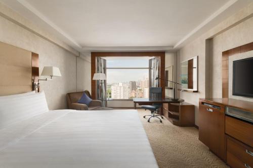 a hotel room with a bed and a television at Shangri-La Shenzhen - Nearby Luohu Border, Outdoor Swimming Pool in Shenzhen
