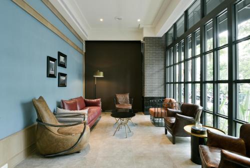 a living room with furniture and a large window at Hotel Kuei in Taichung