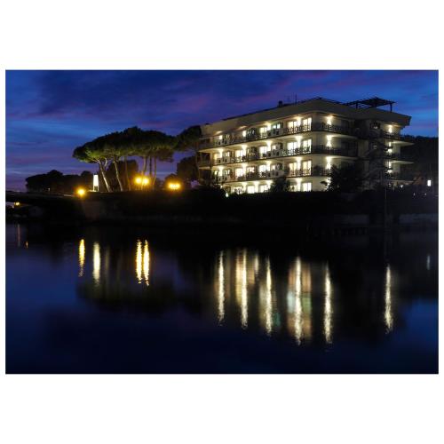 a building at night with its reflection in the water at Michelangelo rta in Cinquale
