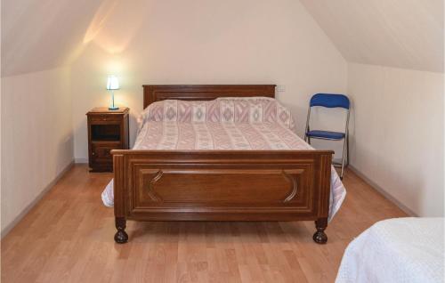 een slaapkamer met een houten bed en een blauwe stoel bij 3 Bedroom Cozy Home In Montfaucon in Montfaucon