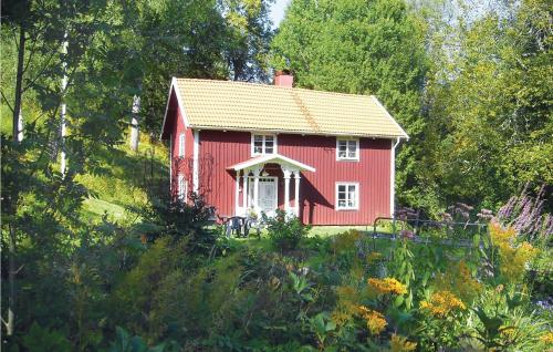 a red house in the middle of a garden at Holiday Home Hatten Forserum in Forserum