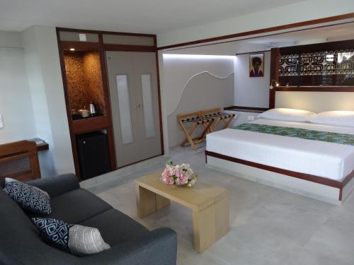 una camera con un grande letto e un divano di Pension Tiputa Lodge Rangiroa a Tiputa
