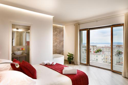 a bedroom with a large bed and a large window at Le Muse Suite in Sorrento