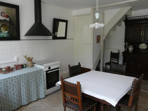 - une cuisine avec une table, une table et une cuisinière dans l'établissement La Promenade en Champagne, à Mussy-sur-Seine