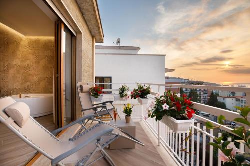a balcony with a chair and flowers on a building at Le Muse Suite in Sorrento