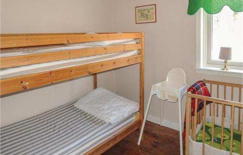 グレンナにあるBeautiful Home In Grnna With 3 Bedrooms And Wifiのベビーベッド付きのドミトリールームの二段ベッド1台分です。