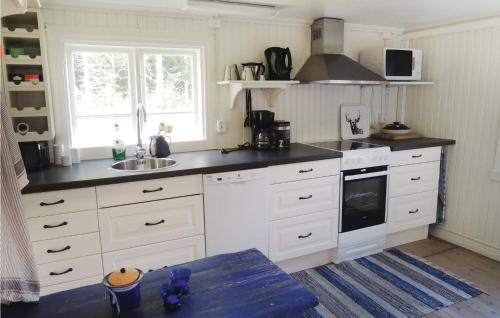 a kitchen with white cabinets and a sink at Awesome Home In Lammhult With Kitchen in Asaryd
