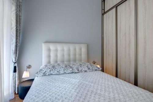トルンにあるAngels Home Toruńのベッドルーム1室(白い掛け布団、枕付)