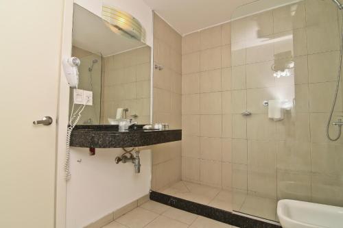 a bathroom with a shower and a sink at De la Plaza Hotel in Maldonado