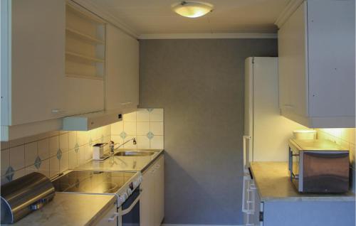 a small kitchen with a sink and a refrigerator at Amazing Home In Nttraby With Kitchen in Nättrabyhamn