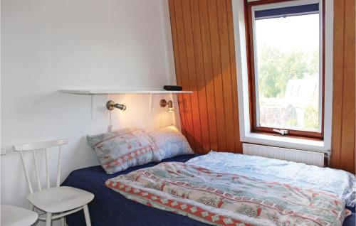 um pequeno quarto com uma cama e uma janela em Pet Friendly Home In Nieuwvliet-bad With Kitchen em Nieuwvliet-Bad