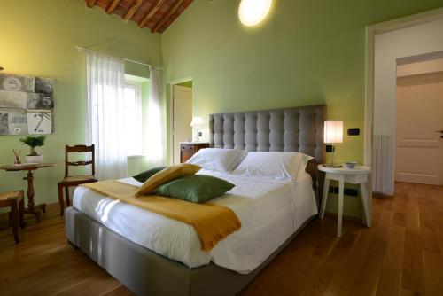 a bedroom with a large bed with white sheets and green walls at ai Santinelli in Lucca